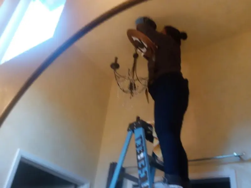 Electrician installing a chandelier in a Richland residence